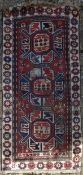 A Shirvan rug with triple star medallions on a madder ground within flowerhead multi borders. L.