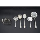 A collection of five 19th century and later English silver spoons along with a silver toast rack,