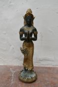 An Indonesian bronze and gilt metal standing praying figure on a bed of lotus leaves. H.45cm