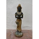 An Indonesian bronze and gilt metal standing praying figure on a bed of lotus leaves. H.45cm