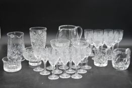 An extensive suite of cut crystal to include port and sherry glasses, champagne cups, vases, water