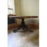 A mid 19th century section veneered figured walnut dining table with tilt top action on turned