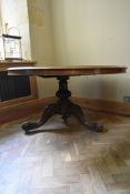 A mid 19th century section veneered figured walnut dining table with tilt top action on turned