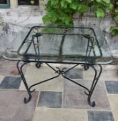 A wrought iron conservatory dining table with bevelled plate glass top. H.73 W.115cm