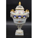 A Dresden neo classical style hand gilded and decorated lidded urn with twin ram's head handles