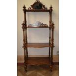 A Victorian rosewood four tier whatnot with pierced carved and mirrored back on turned supports. H.