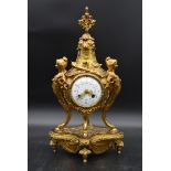 A French style brass mantel clock with garland and pineapple finial, the enamel face supported by