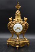 A French style brass mantel clock with garland and pineapple finial, the enamel face supported by