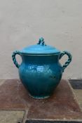 An Eastern turquoise glazed lidded storage pot with twin rope design handles and finial. H.45 Dia.