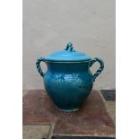 An Eastern turquoise glazed lidded storage pot with twin rope design handles and finial. H.45 Dia.