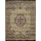 A large carpet with floral central medallion on a biscuit ground within foliate spandrels and