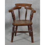 A 19th century elm child's stick back armchair with moulded seat above turned stretchered