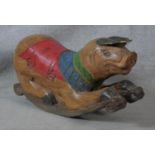 An Eastern carved and painted hardwood polychrome child's rocking pig. H.40 L.80cm