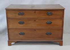A Georgian mahogany chest of three long graduated drawers with original handles on bracket feet. H.