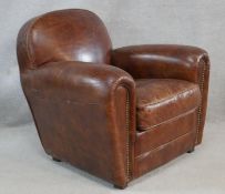 A contemporary vintage style armchair in studded tobacco upholstery on block supports. H.76 W.87 D.
