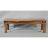 An Indian hardwood metal bound and studded low table on circular section supports. H.41 L.136 W.61.