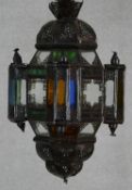 A Moorish design pierced metal hanging lantern with coloured glass panels. H.59cm