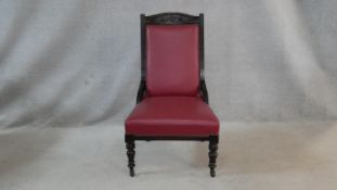 A Victorian carved frame nursing chair in faux leather upholstery on turned tapering supports. H.