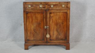 A late Georgian figured mahogany side cabinet with caddy top above a pair of drawers and panel doors