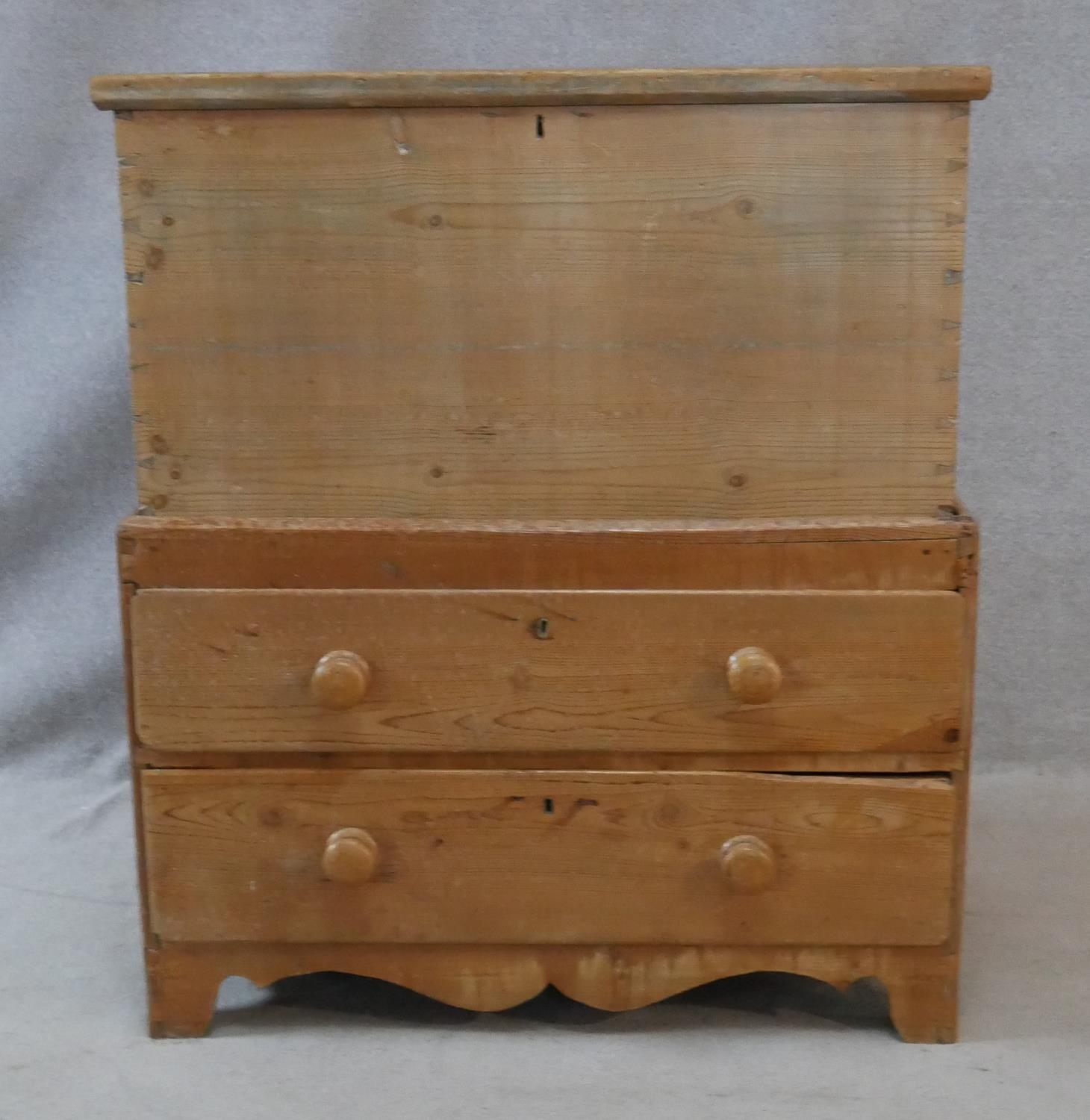 A 19th century pine mule chest with lidded coffer section fitted with candle slide above two drawers