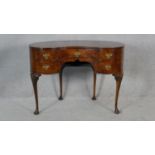 A mid century burr walnut Queen Anne style kidney shaped dressing table on shell carved cabriole