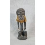 A carved hardwood African tribal figure with coconut husk beard. H.43cm