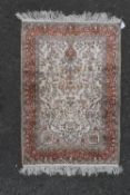 A Persian style silk prayer rug with scrolling floral design on a fawn field within bird and