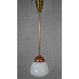 A vintage brass and copper ceiling light pendant with milk glass shade. L.82.5cm