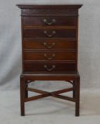 An Edwardian mahogany music cabinet fitted with five hinged fall front sheet music drawers raised on