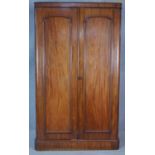 A 19th century mahogany wardrobe with arched panel doors enclosing hanging space (one side