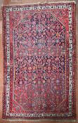 A North West Persian rug with repeating floral decoration across the midnight field contained by