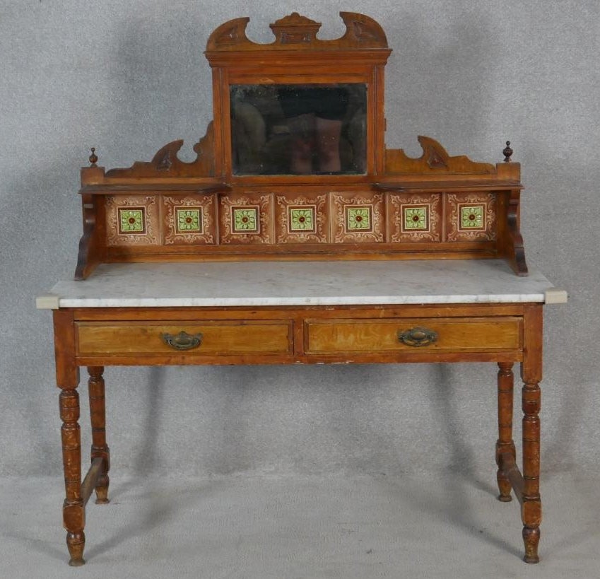 A late Victorian satin walnut washstand with carved and tiled mirrored upstand above marble top