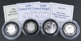 Four proof fifty pence coins. Including a 1998 Silver proof 50p coin for the 25th anniversary of the