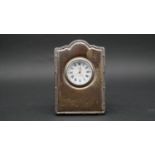 A velvet backed silver fronted easel desk clock by Richard Carr. White enamel dial, gilded