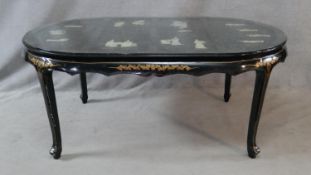 A Chinese black lacquered dining table with applied figural decoration and hand painted detail on