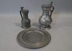 A collection of pewter. Including a lidded flagon with acorn detailing, a large lidded flagon with