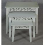 A nest of three graduating painted Eastern tables with carved friezes raised on square tapering