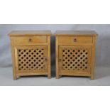 A pair of Eastern hardwood bedside cabinets with frieze drawers above lattice panelled cupboard