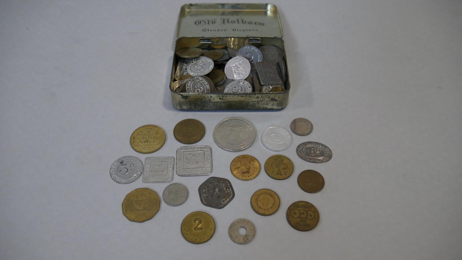 A vintage tin filled with a large collection of antique and vintage shop, gaming and other tokens. - Image 2 of 6