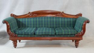 An early Victorian mahogany framed three seat sofa with carved scrolling foliate decoration and