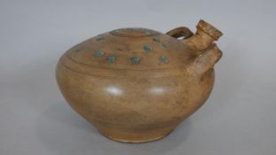 A ceramic glazed Persian water vessel with spout and two handles. Turquoise glaze dots to the