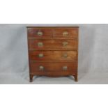 A Regency mahogany chest of drawers with original floral embossed brass plate handles on swept