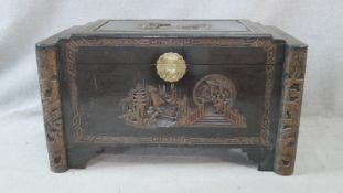 A Chinese camphor coffer with all over carved figural decoration. H.58.5 W.103.5 D.54cm
