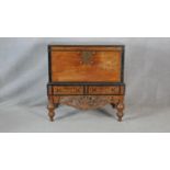 A Nineteenth Century Ceylonese hardwood and ebonised coffer on carved stand fitted with two base