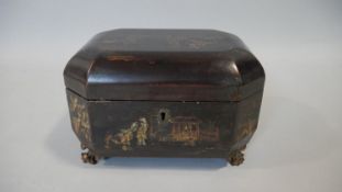 A Georgian jappaned lacquered lidded box with hand gilded and painted decoration on carved gilt wood