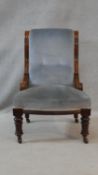 A 19th century mahogany framed nursing chair in buttoned upholstery on turned tapering supports. H.