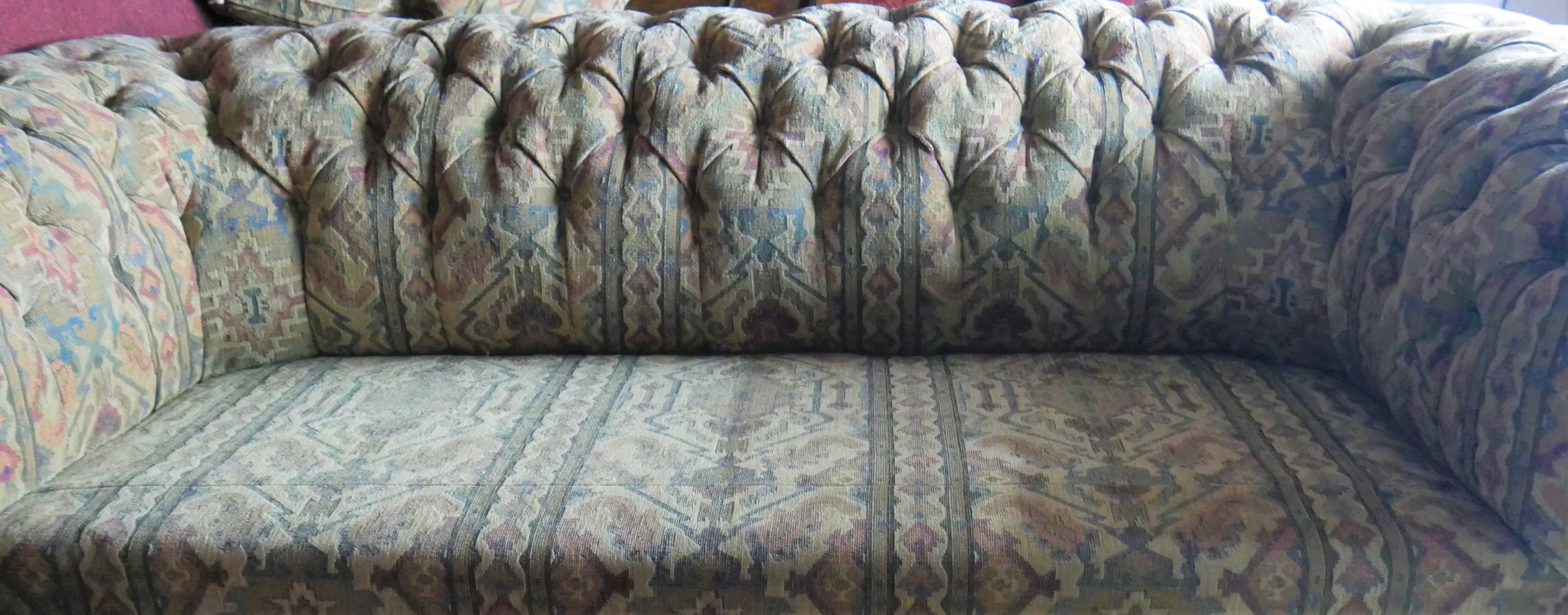 A Victorian style buttoned back Chesterfield sofa in tapestry style upholstery on turned tapering - Image 5 of 5