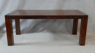 A hardwood parquetry topped dining table with joined and cleated ends on square section supports.