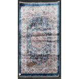 A Persian style rug with central floral medallion on a sapphire ground contained by naturalistic