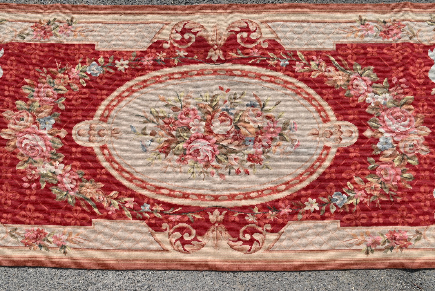 A needlepoint rug with central floral cartouche on a burgundy field within ribbon and flowerhead - Image 2 of 4